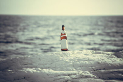 Bottle of beer with blank label on the beach - slon.pics - free stock photos and illustrations