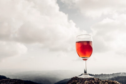 A glass of rose wine in front of a mountainous landscape - slon.pics - free stock photos and illustrations