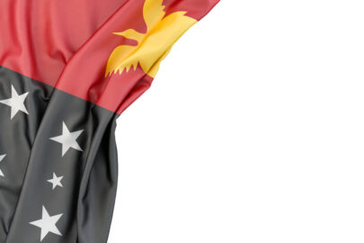 Flag of Papua New Guinea in the corner on white background. Isolated, contains clipping path - slon.pics - free stock photos and illustrations