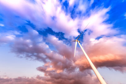 Wind turbine in action against a cloudy blue sky - slon.pics - free stock photos and illustrations