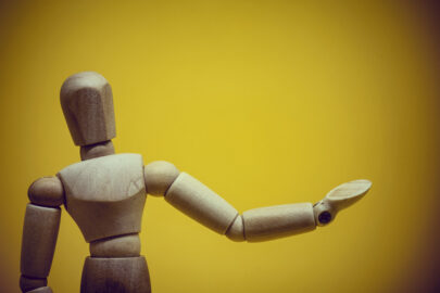 Wooden mannequin presenting invisible object - slon.pics - free stock photos and illustrations