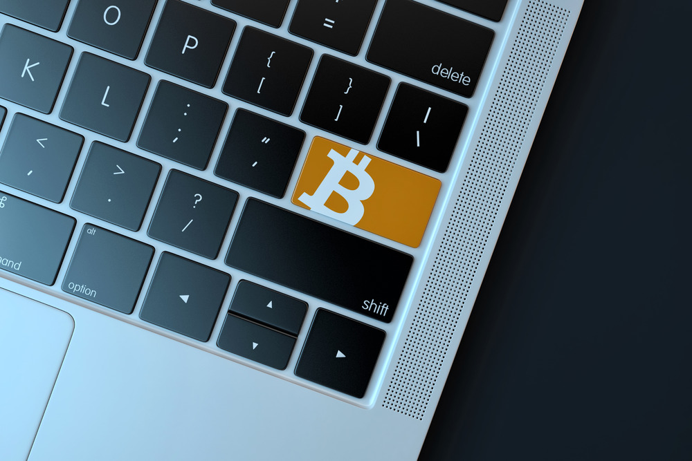 Bitcoin icon on laptop keyboard. Technology concept