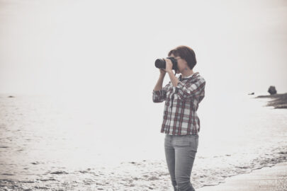 Woman taking photographs with DSLR on the beach - slon.pics - free stock photos and illustrations